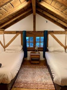 two beds in a room with two windows at Gorgeous Mini-Chalet Chamonix in Chamonix-Mont-Blanc