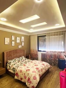 1 dormitorio con 1 cama con colcha de flores en Log. standing complet 180 m2 en Sousse