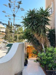 una pasarela con palmeras frente a un edificio en Log. standing complet 180 m2 en Sousse