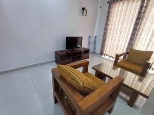 a living room with a couch and a table and a tv at 3B in Dehiwala