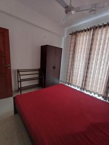 a bedroom with a large bed with a red blanket at 3B in Dehiwala