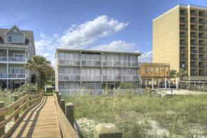 een gebouw op het strand met een houten promenade bij Seaside Elegance Your Coastal Getaway in Myrtle Beach