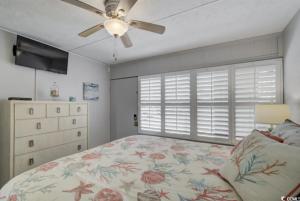 een slaapkamer met een bed en een plafondventilator bij Seaside Elegance Your Coastal Getaway in Myrtle Beach