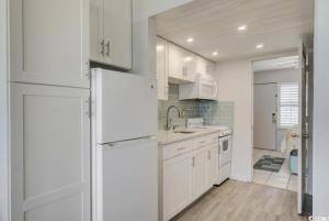 een keuken met witte kasten en een witte koelkast bij Seaside Elegance Your Coastal Getaway in Myrtle Beach +13 foto's