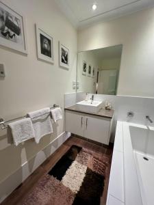 a white bathroom with a sink and a mirror at Private Gem in Pacific Pines in Gold Coast