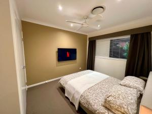 a bedroom with a bed and a window at Private Gem in Pacific Pines in Gold Coast