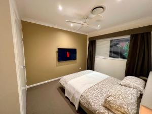 um quarto com uma cama e uma janela em Private Gem in Pacific Pines em Gold Coast