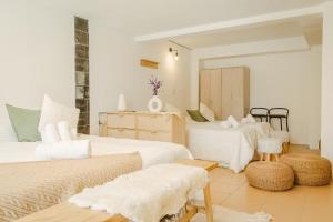 a bedroom with three beds with white sheets at Hosteria Boutique Bariloche in San Carlos de Bariloche