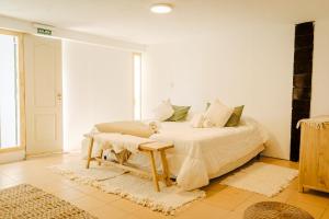 a white bedroom with a bed and a table at Hosteria Boutique Bariloche in San Carlos de Bariloche