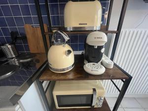 a shelf with a blender and a microwave on it at Le Duo de la Foret - Logement F1 in Sahurs