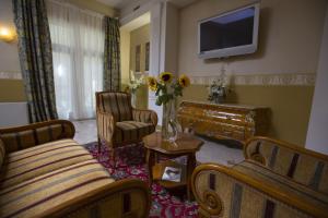 a living room with a couch and a tv at Hotel Tyl in Prague