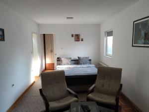 una camera con un letto e due sedie di Nikolic Apartment a Leskovac