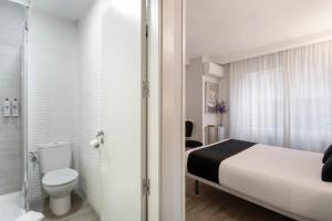 サモラにあるAlda Centro Zamoraのベッドとトイレ付きのホテルルーム