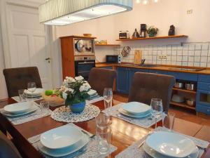 a dining room with a table with plates and glasses at DEUTSCHE OSTSEEVILLA - große Villa mit Sauna, Spielplatz, PKW-Stellplätze, großer Garten in Rostock