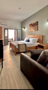 een slaapkamer met een groot bed en een bank bij Royal Goddess Guest House, Walled City in Famagusta