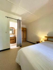 a bedroom with a bed and a door to a bathroom at Umoja Guesthouse II in Ouagadougou