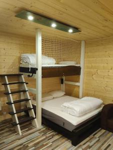 two bunk beds in a wooden cabin with a ladder at Petit appartement Andernos in Andernos-les-Bains