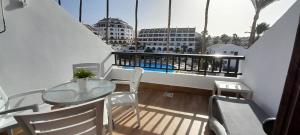 a balcony with a table and chairs and a view of a building at Santiago 2 Las Americas duplex 2 Dormitorios in Playa de las Americas