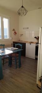 a kitchen with a table and a table and a table and a kitchen at Mon gîte au Jura in Lavans-lès-Saint-Claude