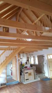 a large room with wooden ceilings and a stone wall at Ferienwohnung Jean Wallhausen in Wallhausen