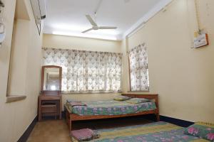 um quarto com 2 camas e uma ventoinha de tecto em 1 Room for 4 Guests OR 2 BHK for 4 to 10 Guests with AC for Families em Hyderabad