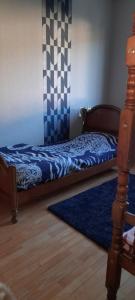 a bedroom with a bed and a blue rug at Mon gîte au Jura in Lavans-lès-Saint-Claude