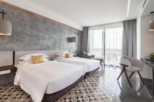 two beds in a hotel room with white sheets at Hotel Vellita Siem reap in Siem Reap