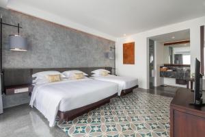 a bedroom with two beds and a television in it at Hotel Vellita Siem reap in Siem Reap