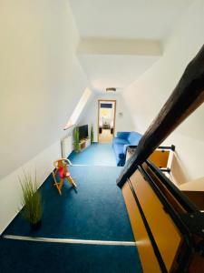 a living room with a staircase with a blue carpet at KAPITÄNS HUS - traditionelles Reethaus strandnah, Sauna, großer Garten, PKW-Stellplätze in Graal-Müritz
