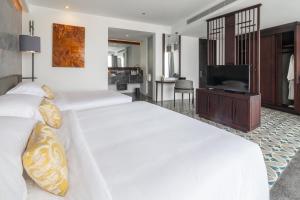 a bedroom with two beds and a flat screen tv at Hotel Vellita Siem reap in Siem Reap