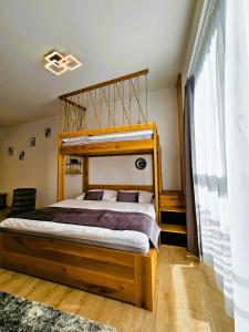 a bedroom with a bed with a wooden bed frame at H11 - Evergreen Tale in Bystrá