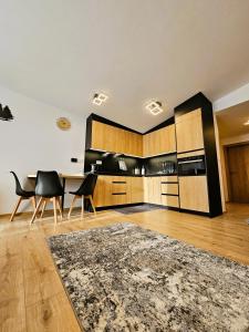 a kitchen with wooden cabinets and a table and chairs at H11 - Evergreen Tale in Bystrá