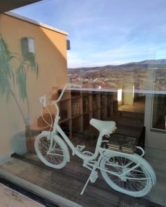 - un vélo blanc garé sur le balcon d'une maison dans l'établissement BIKEINN, à Vouzela
