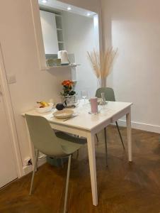 un tavolo bianco con sedie in una stanza di Appartement moderne Quartier Saint Lazare a Parigi