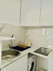 a kitchen with a sink and a washing machine at Appartement moderne Quartier Saint Lazare in Paris