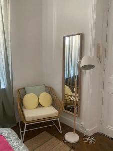 una stanza con una sedia, uno specchio e una lampada di Appartement moderne Quartier Saint Lazare a Parigi