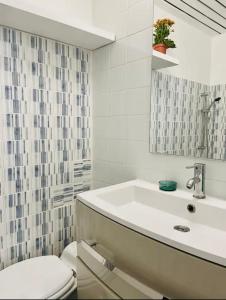 bagno bianco con lavandino e servizi igienici di Appartement moderne Quartier Saint Lazare a Parigi