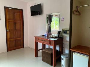 a room with a desk and a mirror and a door at Sabai House in Phi Phi Islands