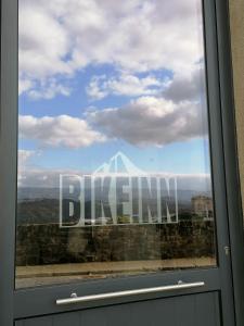 uma janela com um sinal que lê a capacidade em BIKEINN em Vouzela