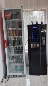 an open cocacola refrigerator next to a drink cooler at Pensiunea Toma in Ploieşti