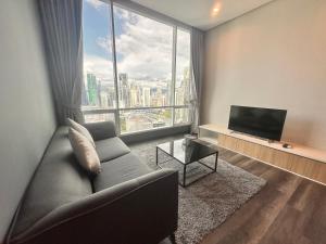 een woonkamer met een bank en een groot raam bij Lovely 2&3bedrooms condo klcc and kL tower view in Kuala Lumpur