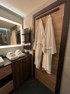 a bathroom with a closet with white robes at Woodside Story in Kopaonik