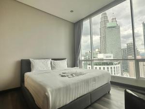 een slaapkamer met een groot bed en een groot raam bij Lovely 2&3bedrooms condo klcc and kL tower view in Kuala Lumpur