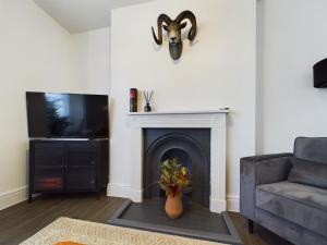 sala de estar con chimenea y máscara en la pared en SunningEnd W King SBed EV Parking, en Cheltenham
