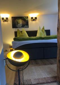 a bedroom with a bed with a yellow table in front of it at Sweet Ferienwohnung Bayreuth City in Bayreuth