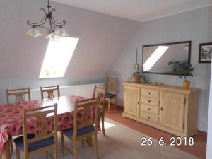 a dining room with a table and a television at Ferienwohnung Hüttenhof Großleinungen in Großleinungen