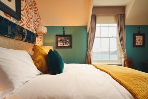 a bedroom with a large bed with a window at The Old Success Inn in Sennen Cove