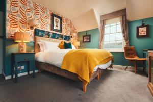 a bedroom with a large bed with a yellow blanket at The Old Success Inn in Sennen Cove