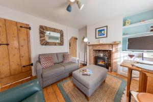 a living room with a couch and a fireplace at Angel Cottage in Southwold