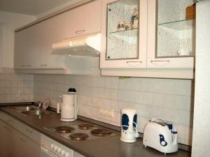 cocina con armarios blancos y encimera en Ferienwohnung Thiele, en Wettelrode